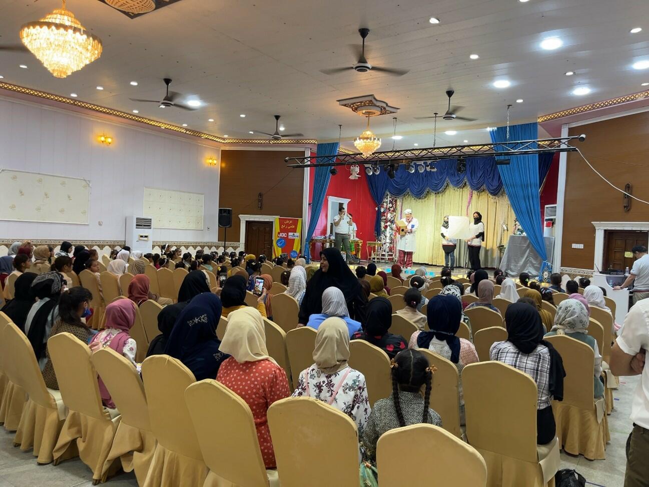 Elementary students attending a science show. Simultaneous Japanese-Arabic interpretation was provided